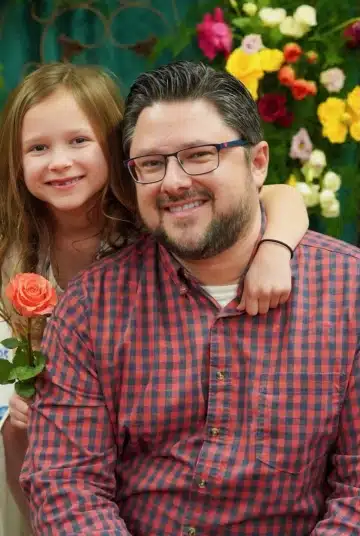 a man and a young girl smiling and posing for the camera