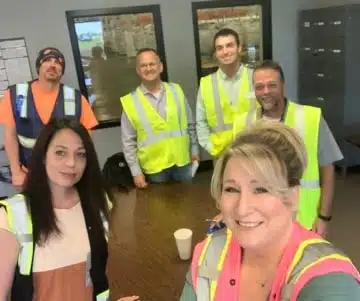a group of people in safety vests posing for the camera