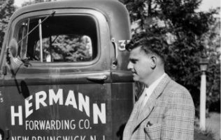 a man standing in front of an old truck
