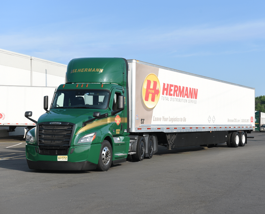 a large green truck is driving down the road